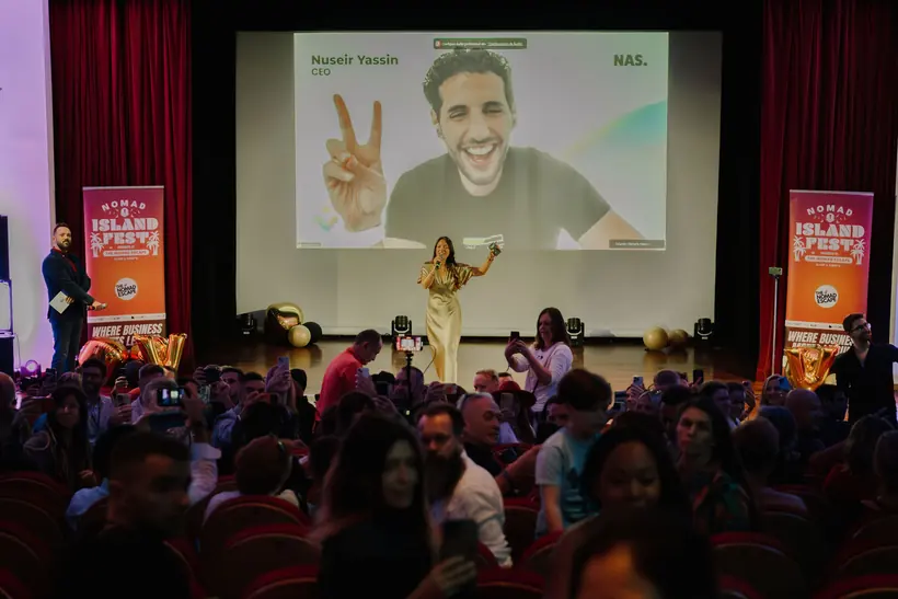 A packed auditorium watching a virtual keynote on the big screen